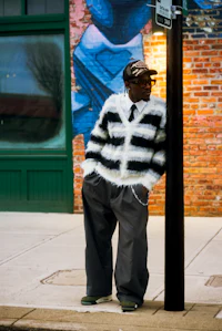 a man leaning against a pole